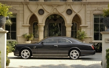 Темный Bentley Brooklands премиум-класса около парадного входа в богатый дом